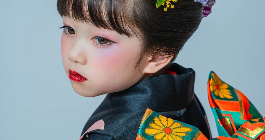 黒い晴れ着に日本髪で振り返る七五三の女の子