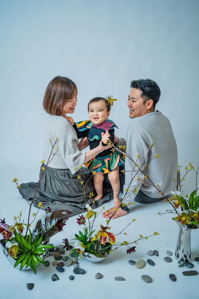 白やベージュの服でそろえた両親と笑顔の子どもの家族写真（白リンクコーデ例）
