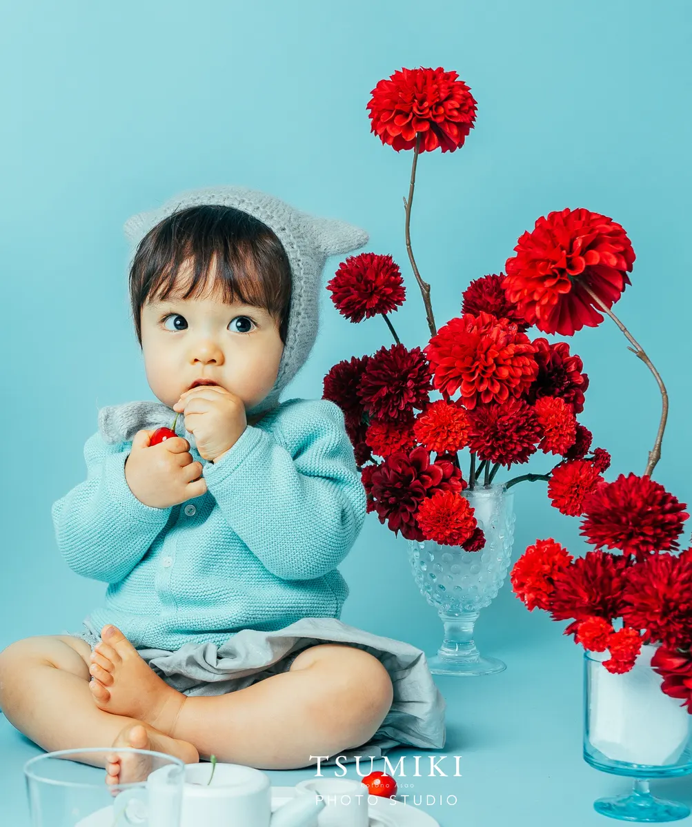 水色の衣装で赤い花を眺める赤ちゃん(Cherry シーン)