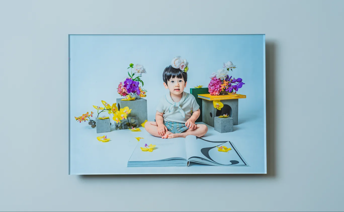花々に囲まれて座る子どもの写真をプリントした Acrylic Panel
