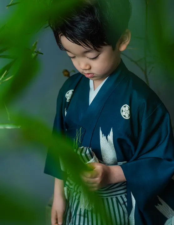 濃紺地に竹柄の羽織に縞袴を合わせた着物「竹林」を着た男の子