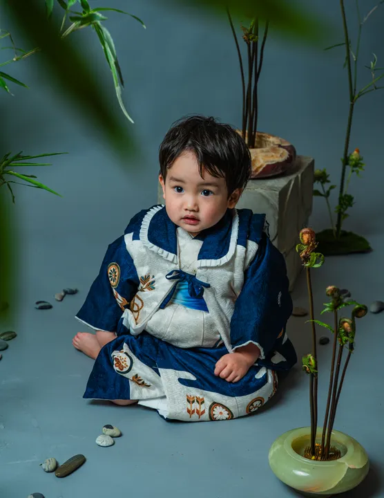 濃紺に車紋などの宝づくし柄の着物「紺」を着た男の子