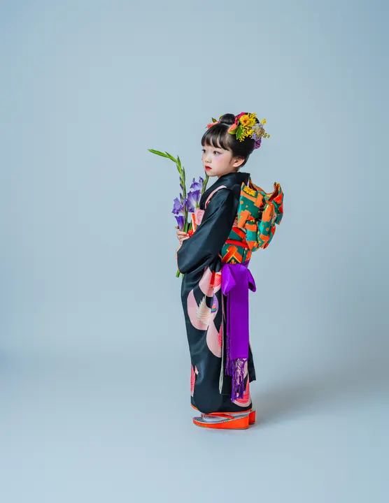 黒地に金彩で孔雀を描いた七五三着物「孔雀」を着た女の子