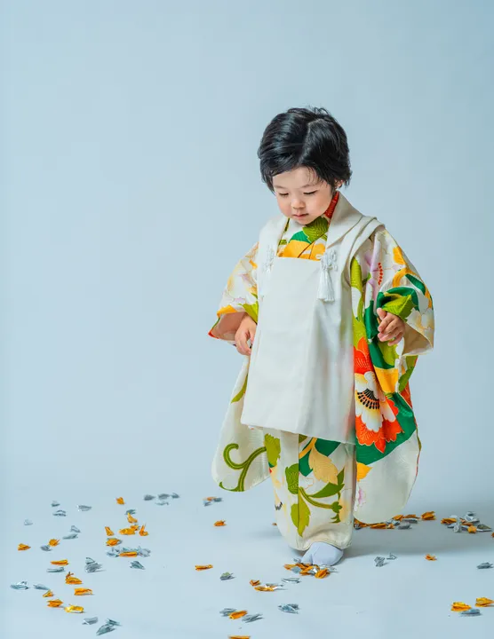 緑地に花柄の着物に白い被布を合わせた「緑華」を着た子ども