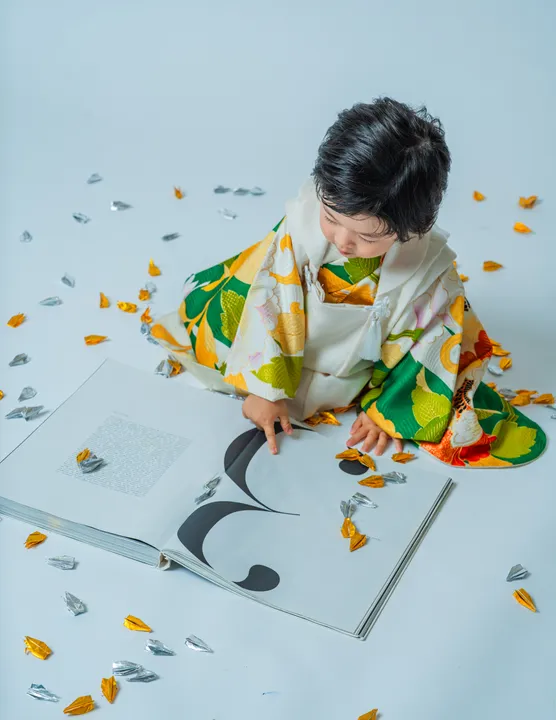 緑地に花柄の着物に白い被布を合わせた「緑華」を着た子ども