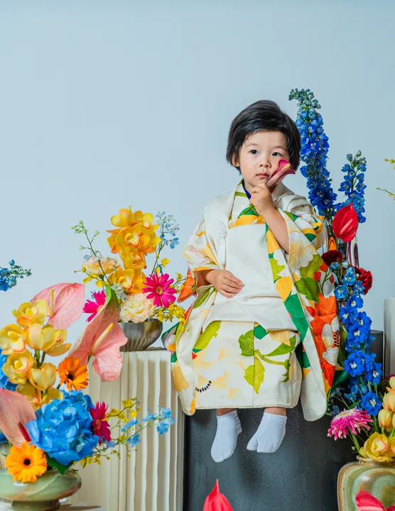 緑地に花柄の着物に白い被布を合わせた「緑華」を着た子ども