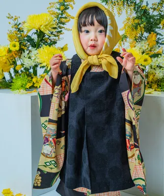 黄色い頭巾と着物姿で黄花を背に立つ七五三の女の子（Bouquet シーン）