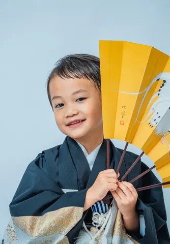 鳥が描かれた扇子を手にする羽織袴姿の七五三の男の子（Engimono シーン）