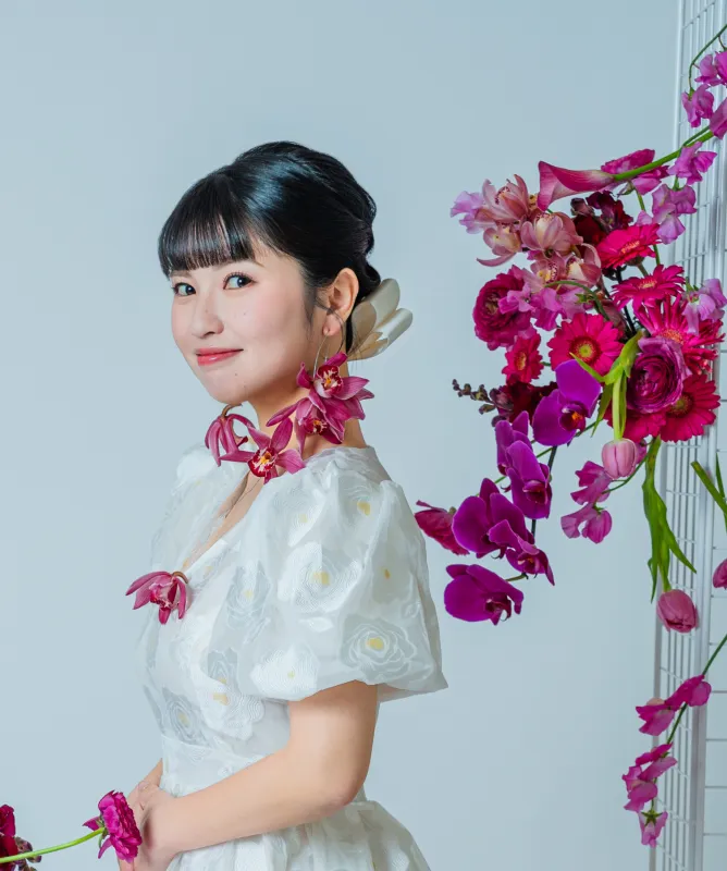 生花のアレンジを背に振り向く花嫁(Flower Crowns シーン)
