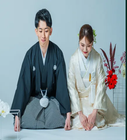 正座して並ぶ黒紋付袴の新郎と白無垢の花嫁(和装シーン)
