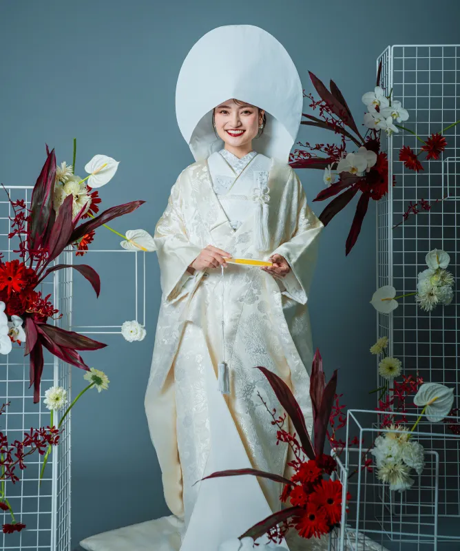綿帽子に白無垢をまとい微笑む和装の花嫁の全身(和装シーン)