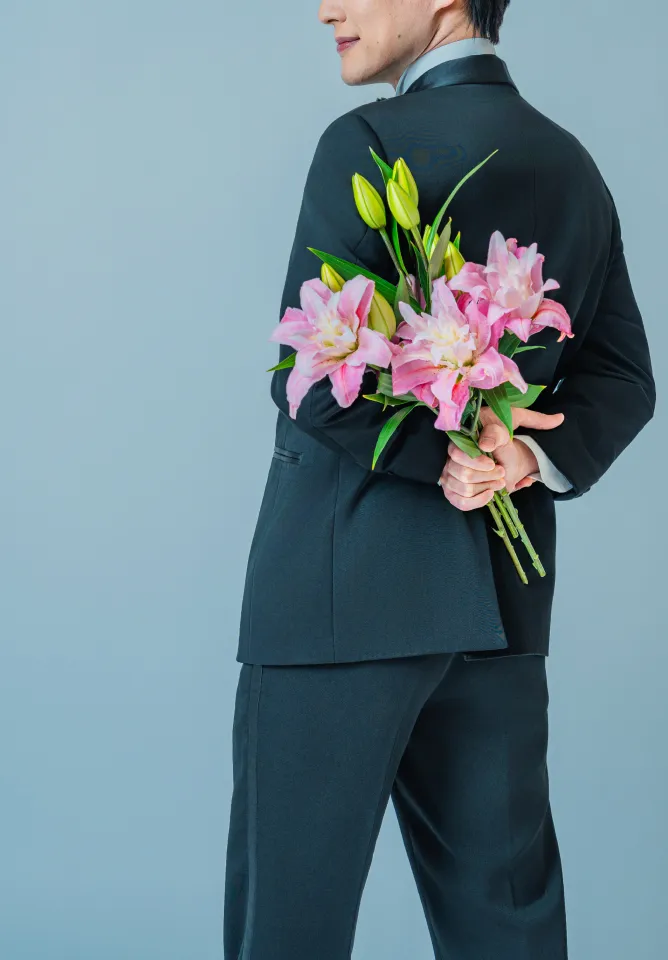 背を向けてピンクのユリの花束を持つ新郎(Simple/Groom シーン)