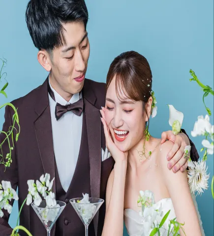 頬に手を添える花嫁に寄り添って微笑む新郎(Table シーン)